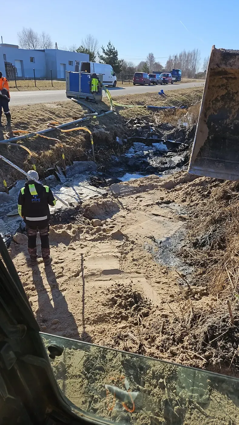 Pipe Service darbinieks avārijas darbos pie maģistrālā ūdensvada noplūdes